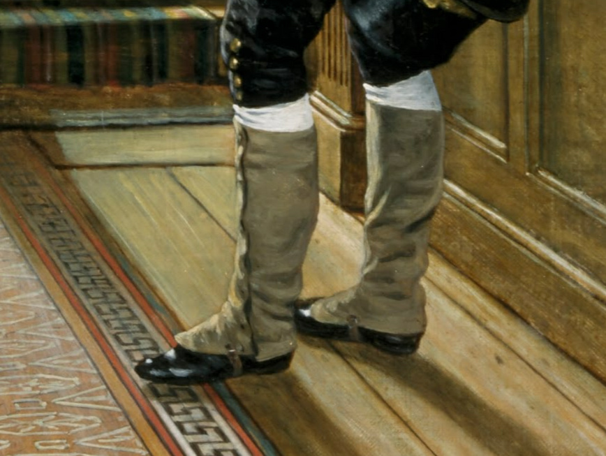 Close-up showing details of spats. They extend from just below his knee down to cover the back and top of his foot. They button up the length of his thigh. the part that extends across the top of his shoe is kept in place by a buckled strap that goes under the arch of his shoe.